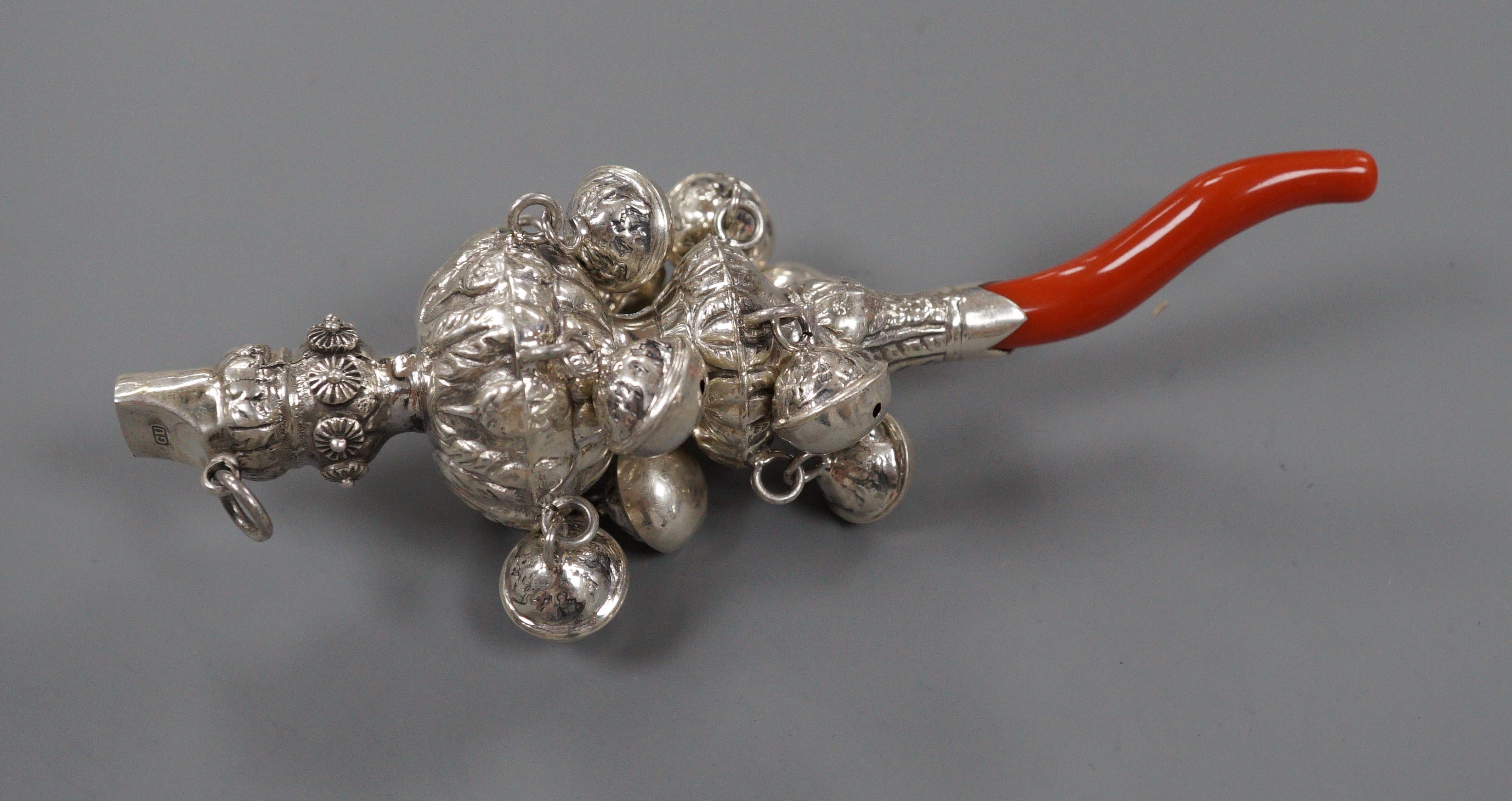 A late 19th/early 20th century white metal and coral set child's rattle, maker's mark only for George Unite, 14cm.